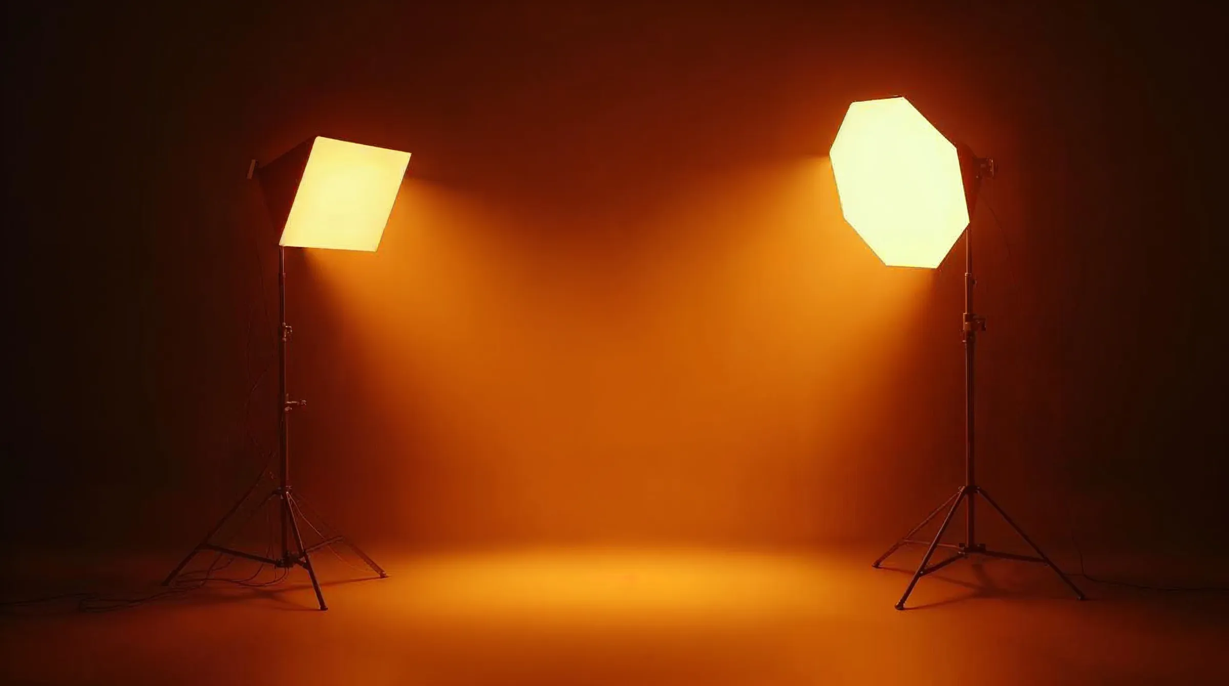 Una luz de estudio y un softbox sobre tripiés en un estudio oscuro